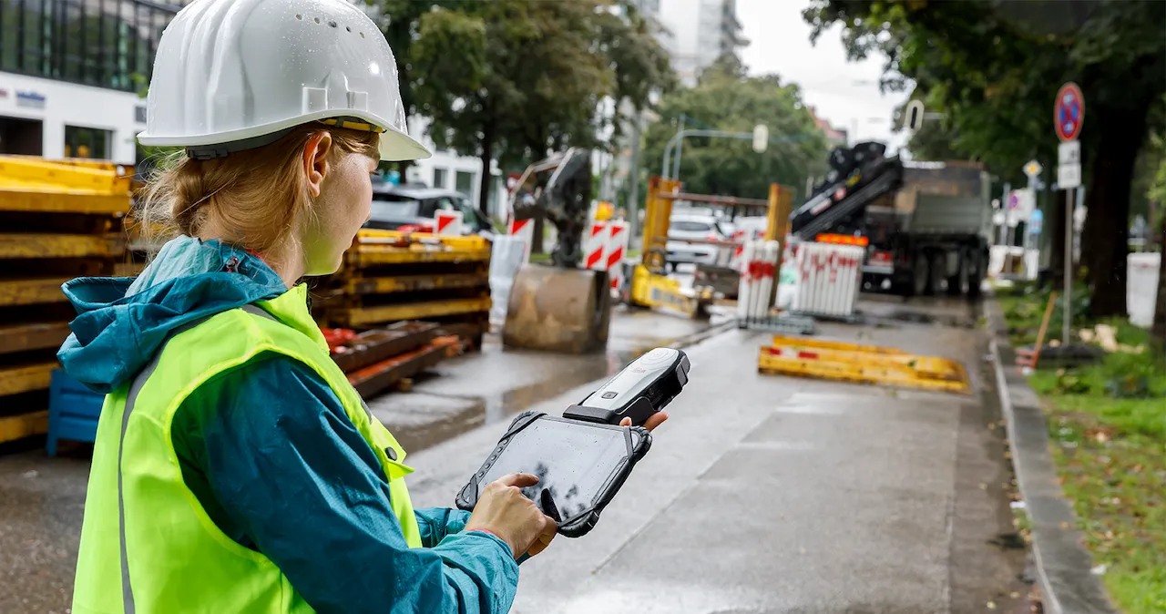 Ingenieurin analysiert Baustelle mit IT-Geräten